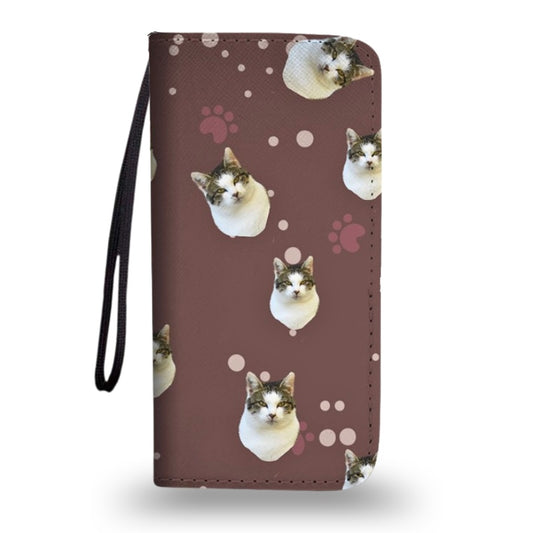 Brown clutch purse with wrist strap, featuring a custom cat face and paw print pattern, shown on a white background