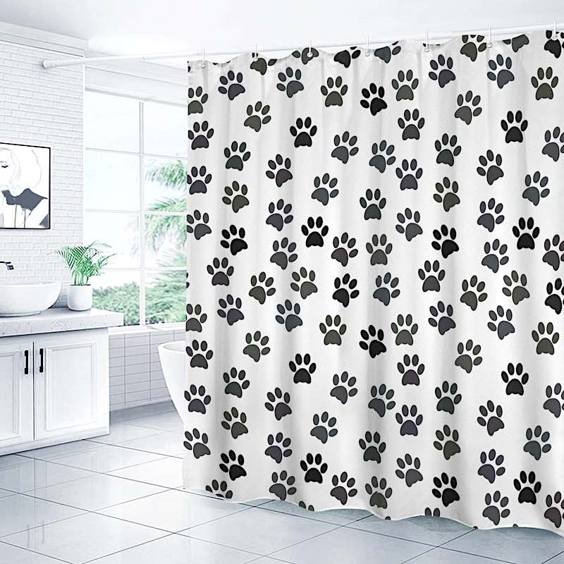Shower curtain with black paw prints on a white background in a bathroom.