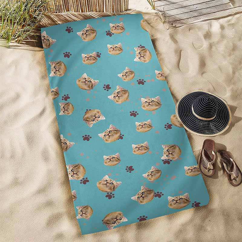 Blue cat print towel on a sandy surface