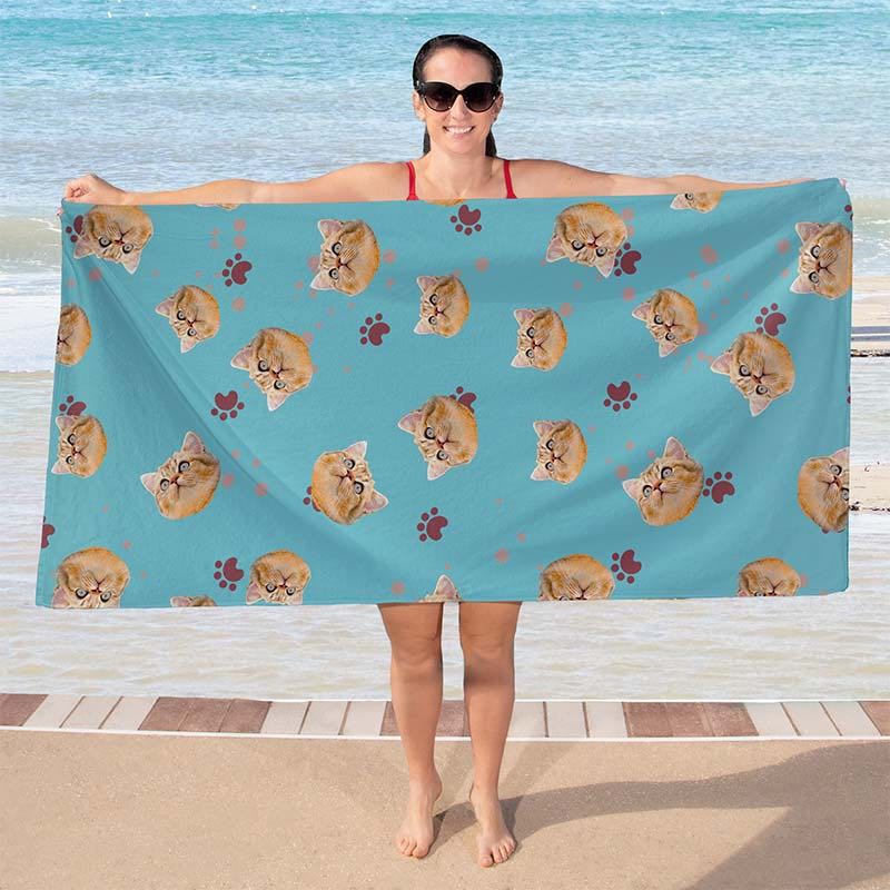 Woman holding a blue cat print towel on a beach