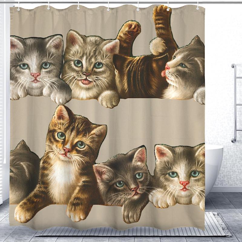 Shower curtain with cat faces printed on it in a bathroom setting.