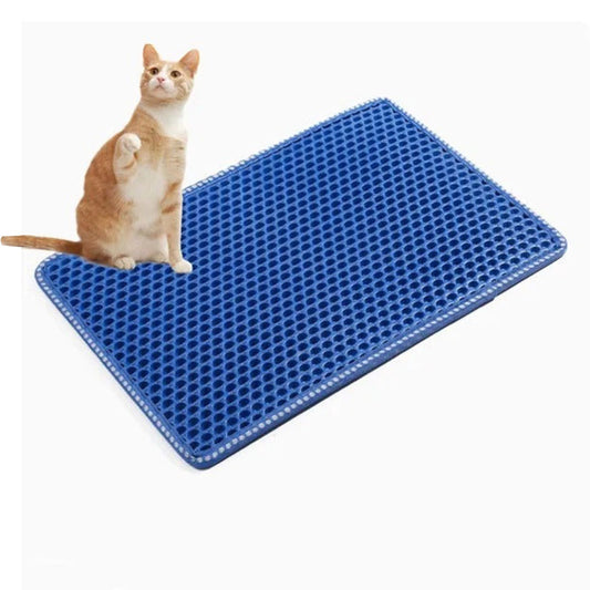 Cat sitting on a blue cat litter mat with a honeycomb pattern.
