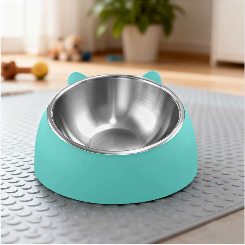 Turquoise pet bowl with a metallic interior on a textured surface.